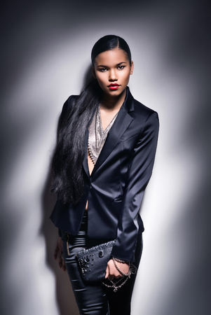 Young woman with black skin on dark backgroundの写真素材