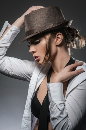 Sexy brunette girl posing in a shirt in the studioの写真素材