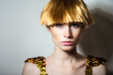 Elegant beautiful blonde woman posing in studio, wearing fashionable dressの写真素材