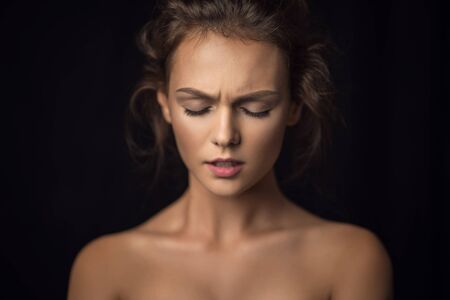Emotional portrait of a beautiful girl against a background in studioの写真素材