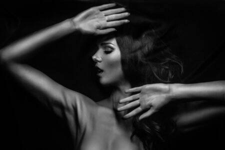 Brunette stretches stretch mesh fabric in front of youの写真素材