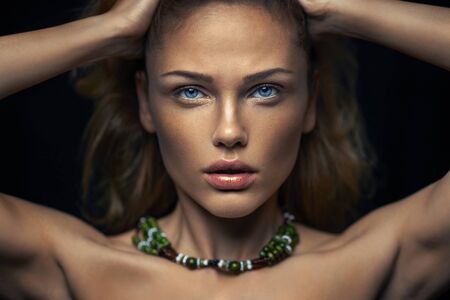 Portrait of a young girl with clean skin on a black background close-up.の写真素材