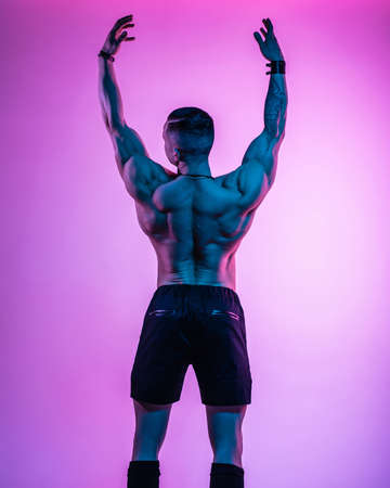 The pumped-out man in the studio in neon glow