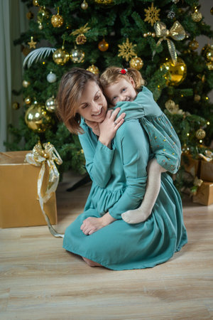 Happy family: mother and daughter next to the Christmas treeの写真素材