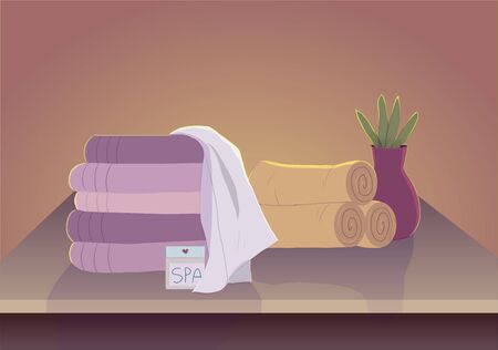 Spa table with towels and plant in pleasant, soothing colors.の写真素材