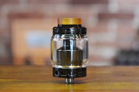 Electronic cigarette on a background of vape shop. E-cigarette for vaping. Popular vape devices