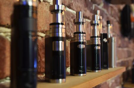 Electronic cigarette on a background of vape shop. E-cigarette for vaping. Popular vape devices