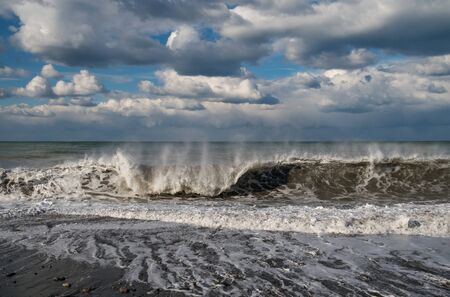 Waves on the beach with cloudy sky background