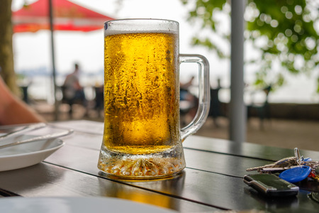 Cold mug of beer on the wooden tableの写真素材