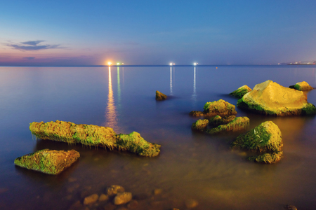 Night coastline with illuminated ships on horizonの写真素材