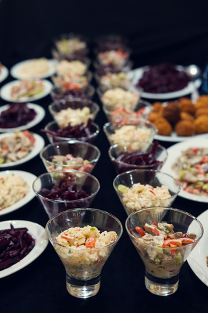 Small salad bowls with salad on the black surface, selective focusの写真素材