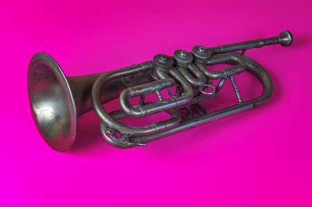 Old silver trumpet on a pink backgroundの写真素材