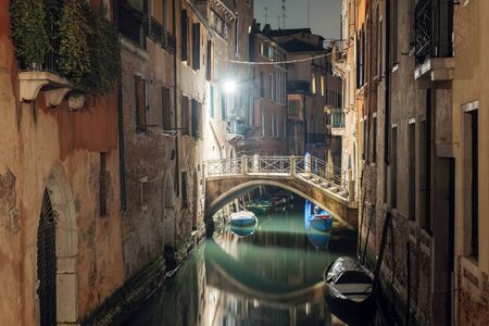 Illuminated bridge over the canal in Venice at nightの写真素材