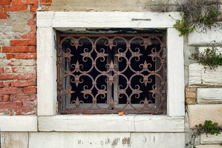 Old vintage gated window on the brick wall