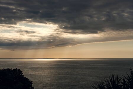 Sun rays through the clouds illuminating the sea