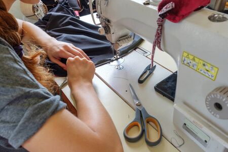 Hands of seamstress sewing with sewing machineの写真素材