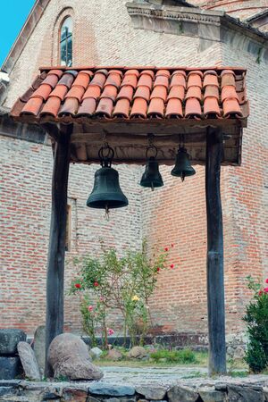 The wooden tilled bell tower with three bells の写真素材