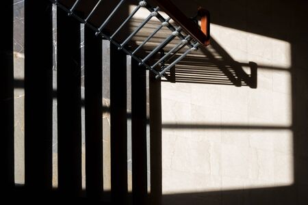 Blurry contours shadows of metal railing on marble stone stairs of classic architecture building.の写真素材