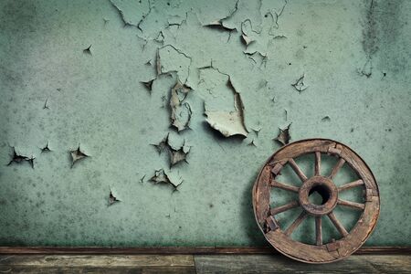 old wooden wheel placed on the grunge wallの写真素材
