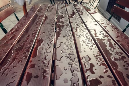 Rain drops on brown wooden table after rain, selective focusの写真素材