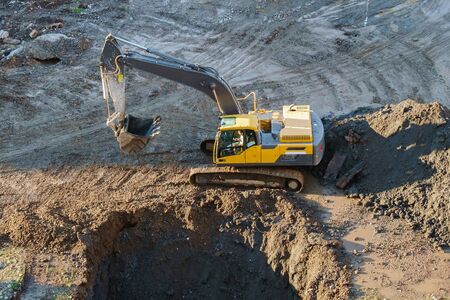 Excavator tractor digging a trench at construction site.
