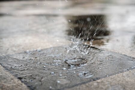 Drops of heavy rain on the pavement, selective focus