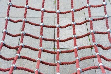 Red braided empty hammock detail with stone pavement backgroundの写真素材