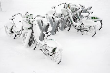 Bicycle parking at winter, row of bicycles covered with snowの写真素材