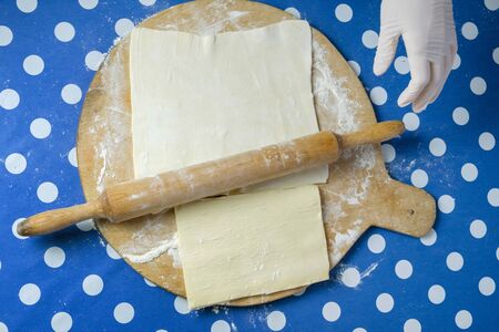 Rolling pin and rolled dough on the wooden cutting board