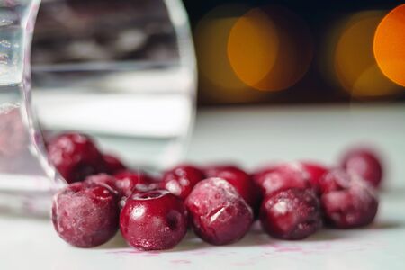 Closeup of frozen cherry in the glass on white surface with dark background. selective focus の写真素材