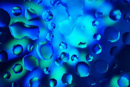 Water drops on a colorful abstract background with gradient green and blue colorsの写真素材