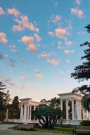 Morning sky with small clouds over the white colonades in the parkの写真素材