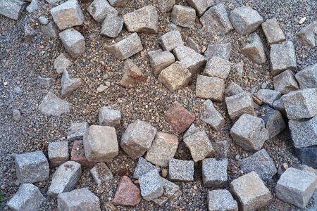 Pile of dusty color natural stone cubes for making outdoor pavement tiles