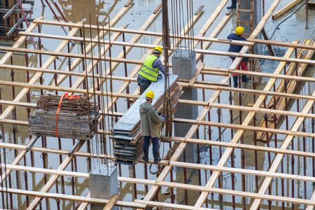 Construction workers working at rainy day on a wet construction siteの写真素材