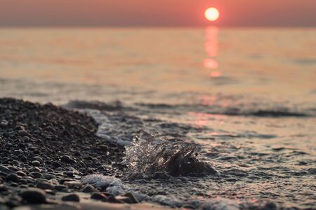 Splashing water on the sunset beach, selective focus
