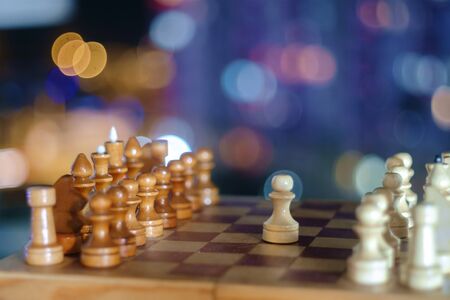 Wooden chess pieces on the chessboard with night abstract background, selective focusの写真素材