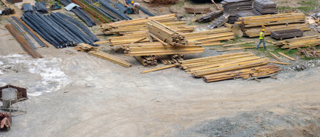 Stacks of wooden and metal materials on the ground at the construction siteのeditorial素材
