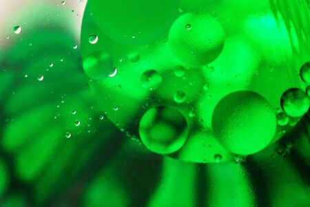 Colorful abstract background with gradient green colors, oil drops in water abstract bubbles...