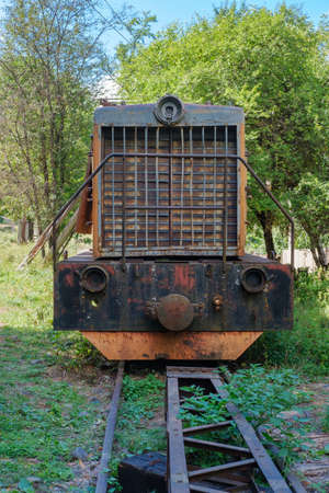Front view of an old rusty broken diesel locomotive standing on railwayの写真素材