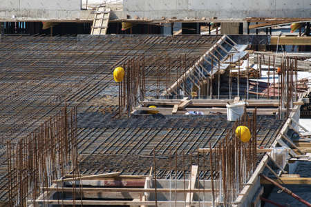 Yellow hard safety helmets on steel structure at construction site