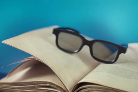 Old vintage opened book with glasses, selective focus