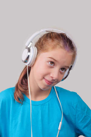 A brown eyed girl wearing headphones and listening to musicの写真素材