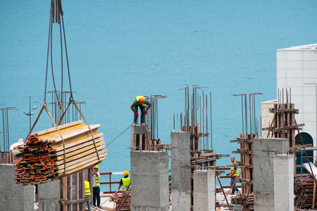 Batumi, Georgia, July 7, 2020:Building worker working on the top of the construction site with blue sea backgroundのeditorial素材