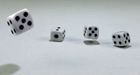 White playing dice cubes in motion on the white canvass surface