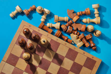 Wooden chess pieces and a chessboard on the blue surfaceの写真素材