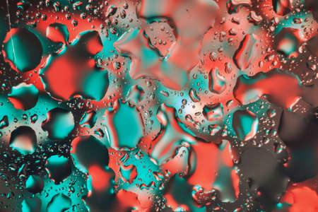Water drops on a colorful abstract background with gradient of red and green colors