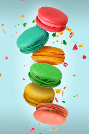Colorful French macaroons falling or flying in motion on a light blue background
