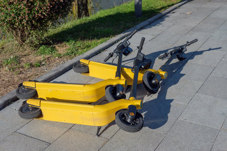 Electric scooters is dumped and fallen over on a sidewalk during storm