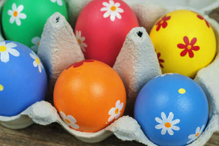 Colorful painted Easter eggs  in a paper tray on a wooden table