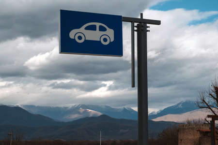 Outdoor car parking sign with mountains and cloudy sky background